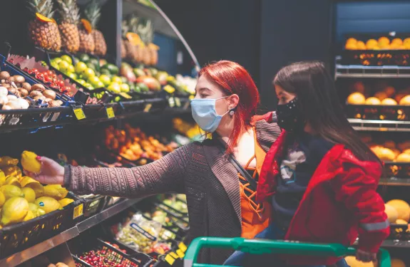 Mother and daughter shopping with face masks