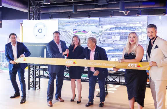 Axis Communications opens new Axis Experience Center in Cincinnati, Ohio. The three images display the Scripps Center, where the Experience Center is located, and two internal views of the office, including the front desk and multiple screens displaying technology in action.