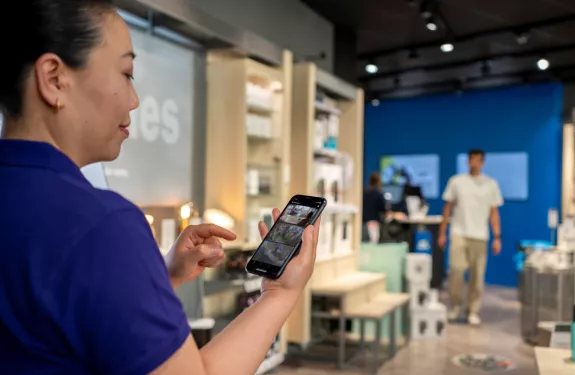 Woman holding a mobile displaying video management software