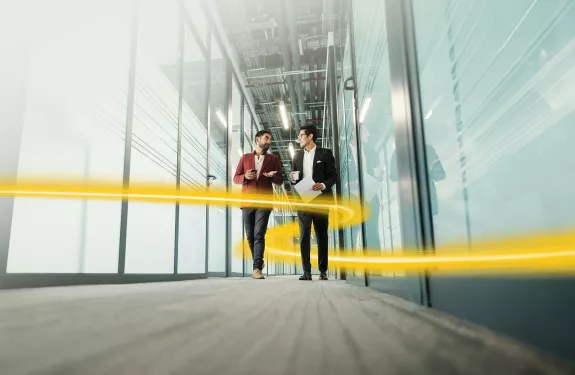 Two people walking through the corridor
