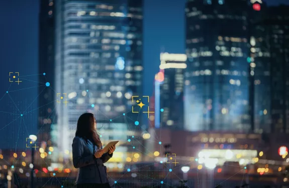 Women holding a device looking at the city