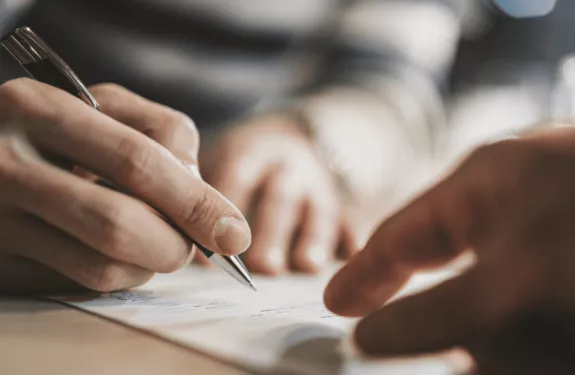 Hands signing grant paperwork