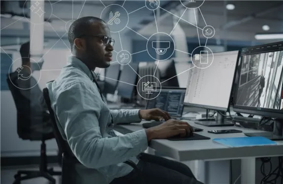 Man at a desk looking at two computer screens