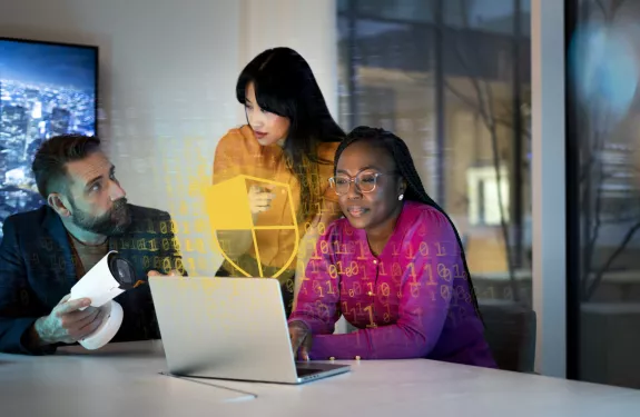 Gruppo di esperti di cybersecurity seduto intorno a un laptop che discute del supporto software nei sistemi di videosorveglianza