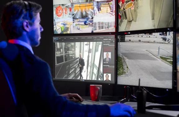 Security officer behind a wall of monitors. 