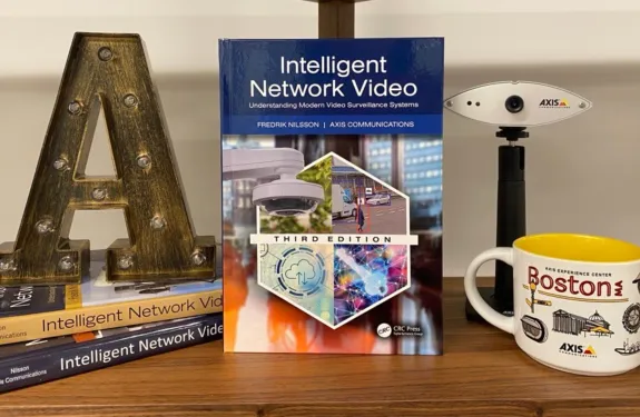 Fredrik Nilsson's book on a shelf with Axis mug, camera, and large A