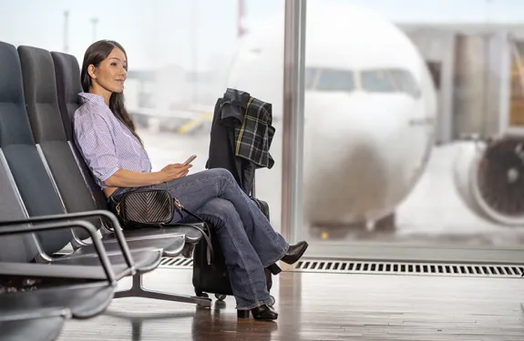 Woman sitting at airport with aeroplane in the backgrand