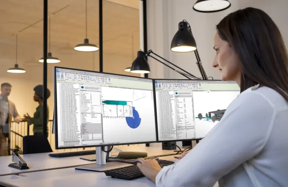 Women sitting in front of a screen showing a multisite management system