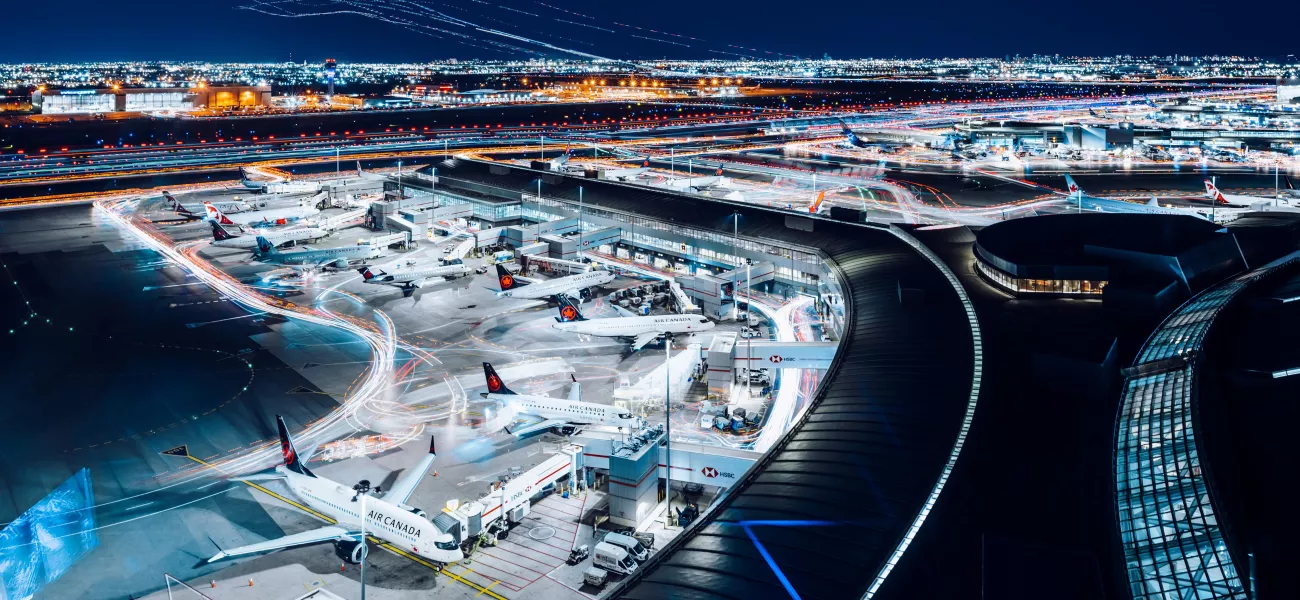 Toronto Pearson Airport at night featuring airplanes at terminal gates