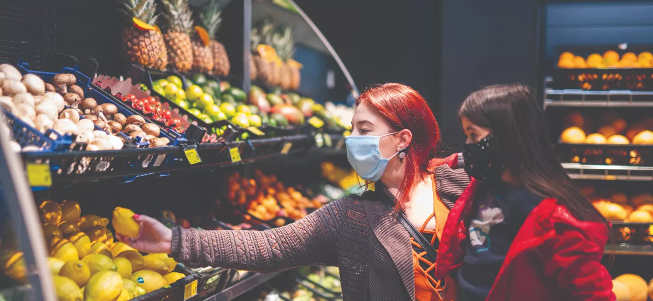 Mother and daughter shopping with face masks