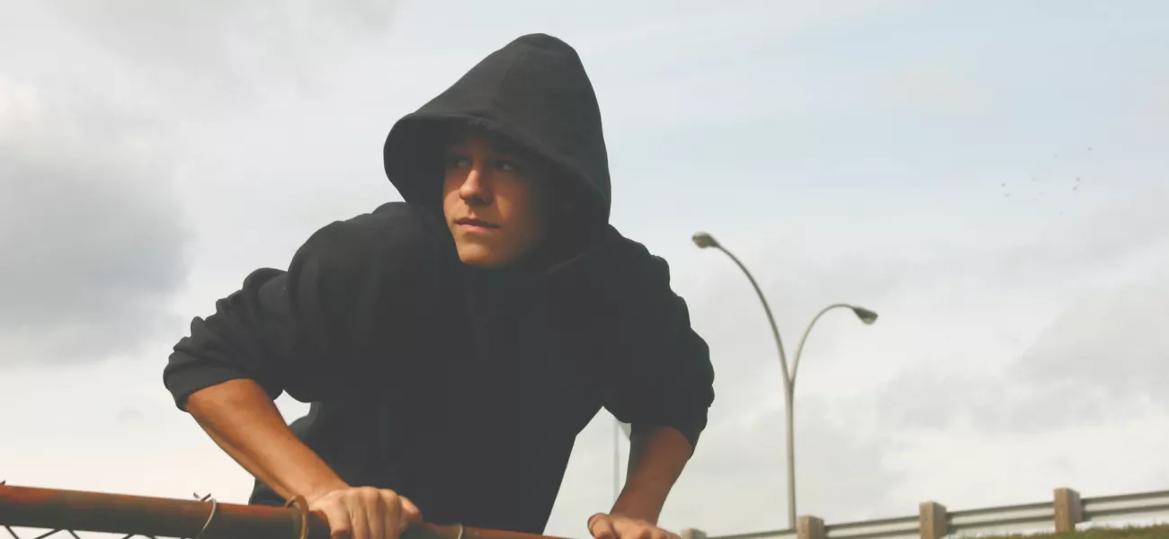 Man climbing fence, triggering a camera with motion detection 