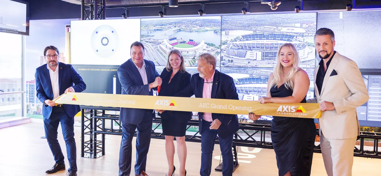 Axis Communications opens new Axis Experience Center in Cincinnati, Ohio. The three images display the Scripps Center, where the Experience Center is located, and two internal views of the office, including the front desk and multiple screens displaying technology in action.