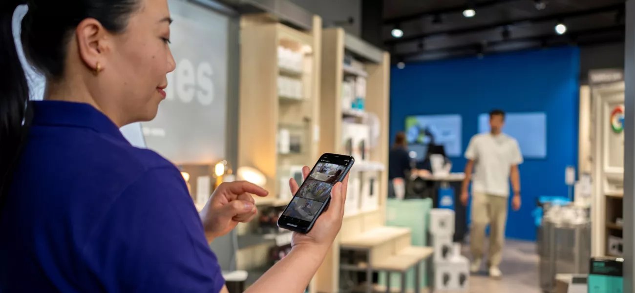 Woman holding a mobile displaying video management software