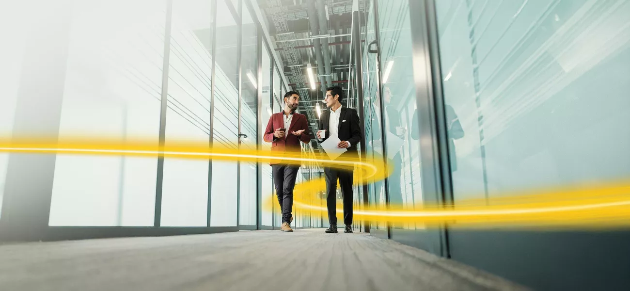 Two people walking through the corridor
