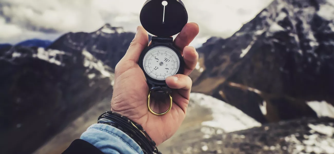 Man's hand holding a compass 