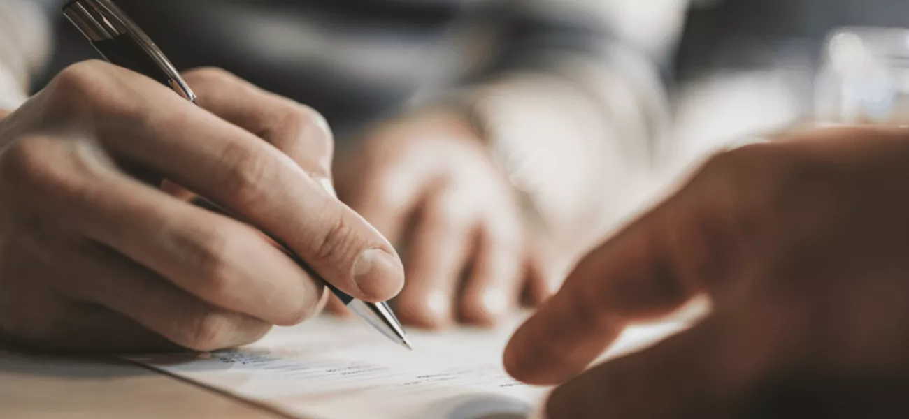 Hands signing grant paperwork