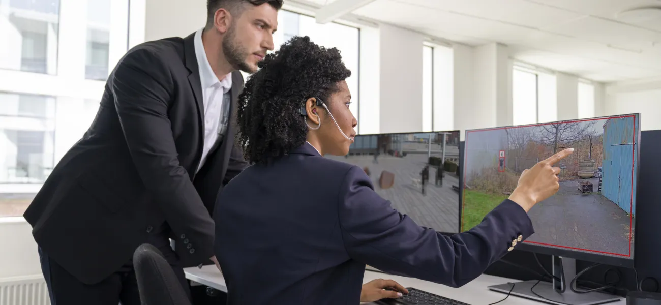 Two people watching a computer screen using video analytic overlays