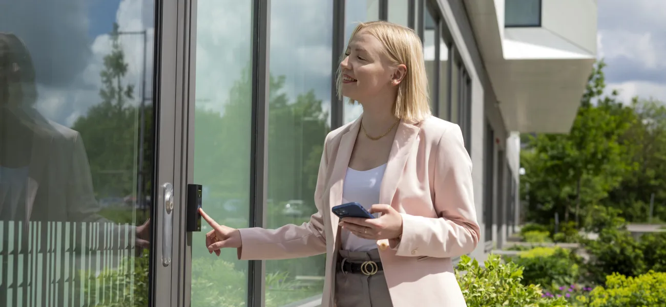 Women using an access control system mounted on a business building