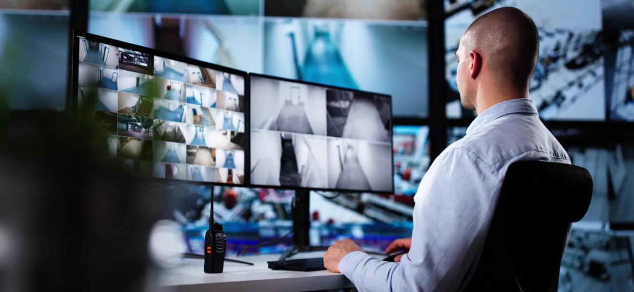 Man sitting in front of screens in a real time crime center (RTCC)