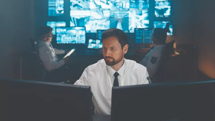 Man sitting in a security monitor room