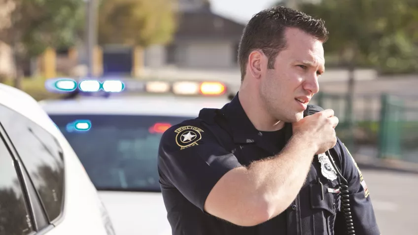 Police officer talking in radio.