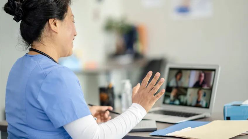 Female healthcare worker in front of computer screen practicing virtual nursing