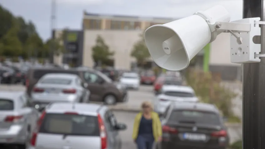 An outdoor PA speaker overlooking a parking lot.