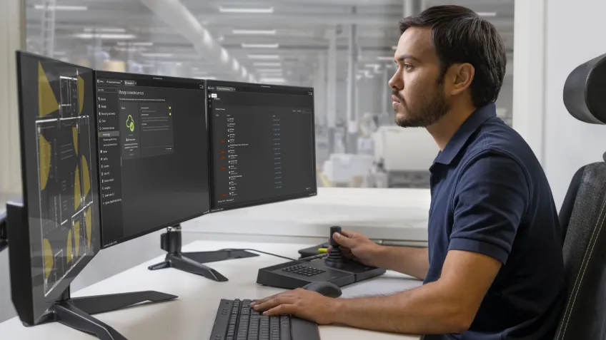 Man sitting in front of screens looking at a cloud video surveillance solution
