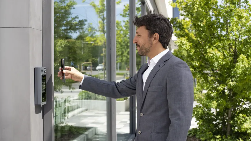 Man using his phone as a credential for a commercial door access control system
