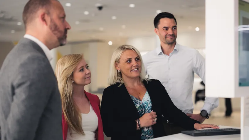4 people looking at a monitor in an Axis Experience Center