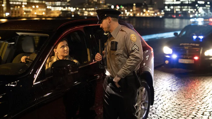 Women being pulled over by a police officer using a body worn camera automatically started together with the dash cam