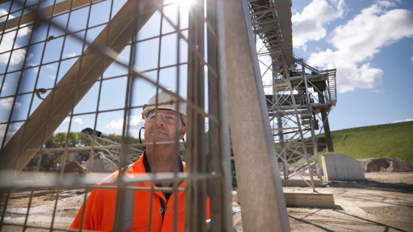 Mine worker investigating the fence securing the mine site perimeter.