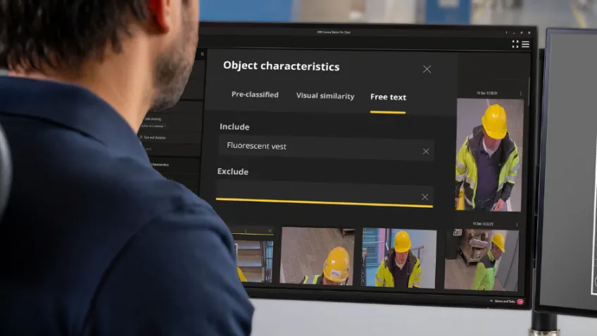 A man sits in front of a computer screen while using object analytics to analyze security footage.