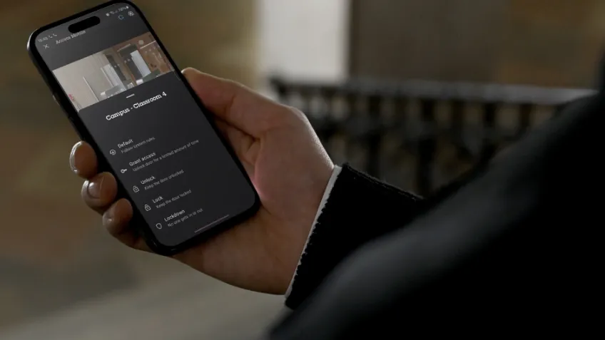 A person monitors a campus security access control feed on their smartphone.