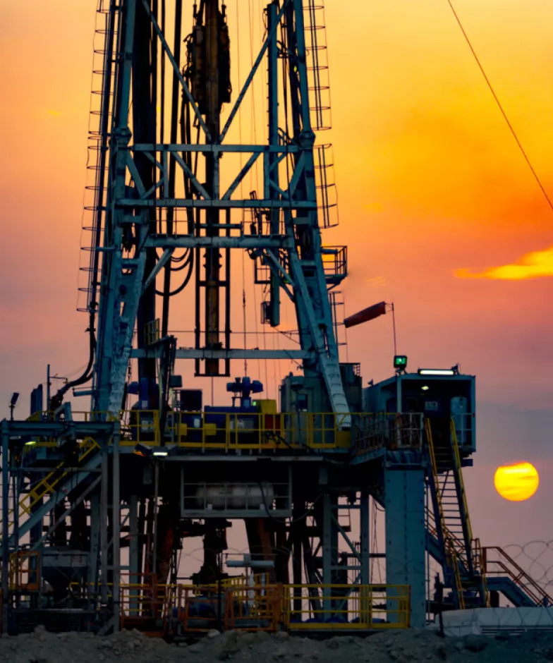 An oil and gas drill in the sunset